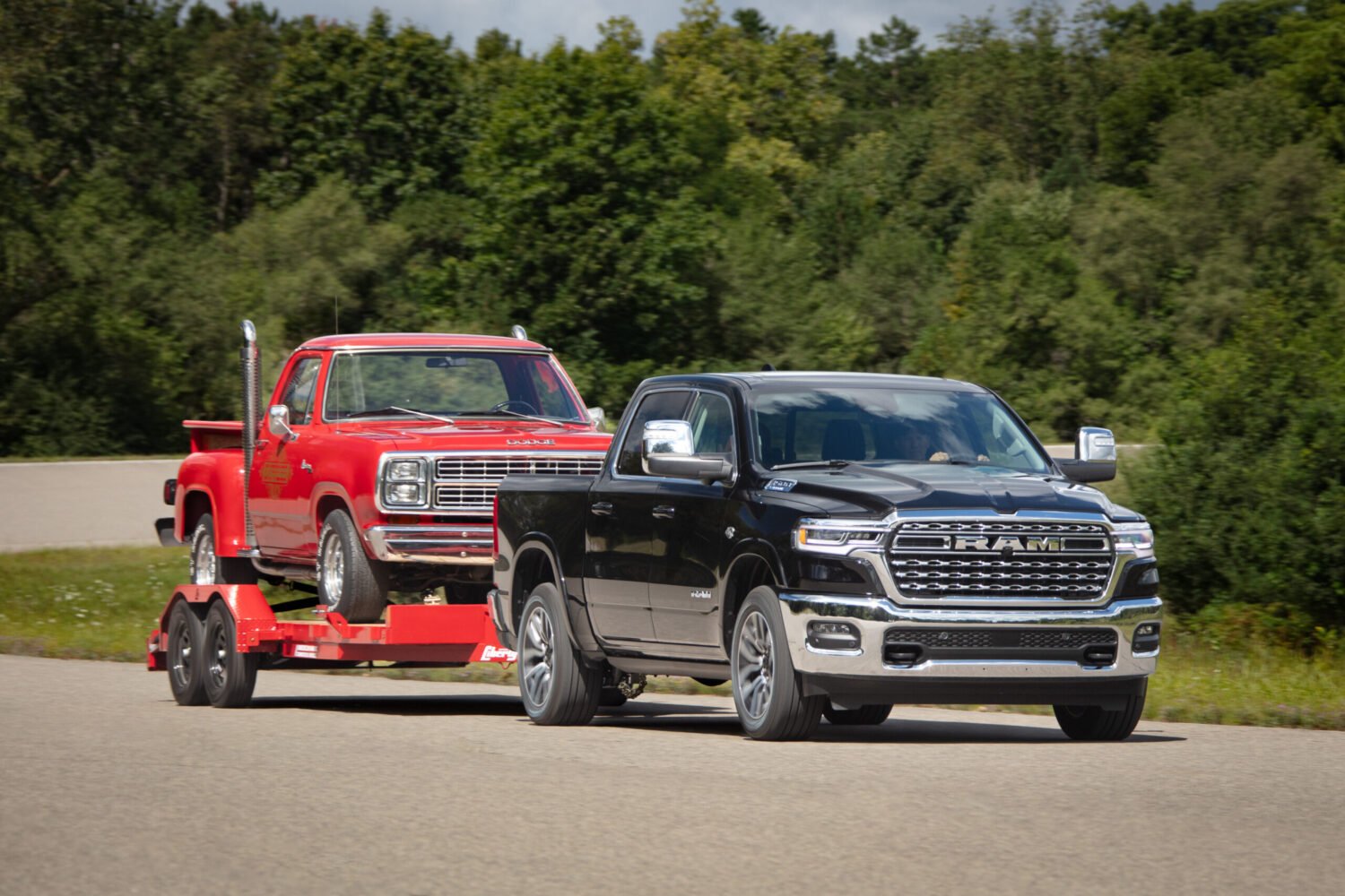 2026 Ram 1500 towing a classic red Dodge pickup on a trailer, featured in Ram 1500 Review