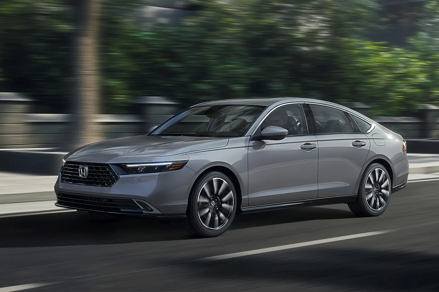 Honda Accord Touring sedan driving on the road, front three-quarter view.