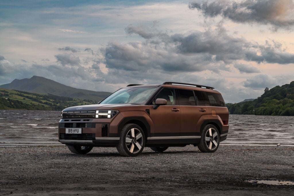 2026 Hyundai Santa Fe parked by a lake with mountains in the background