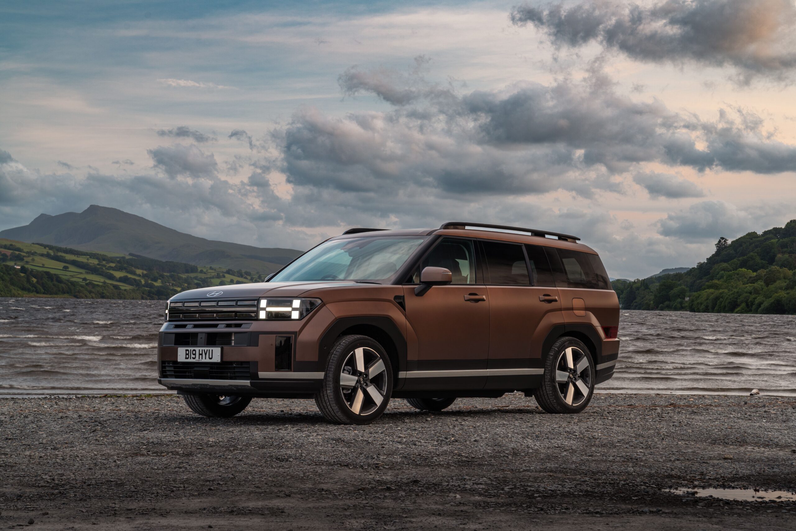 2026 Hyundai Santa Fe parked by a lake with mountains in the background