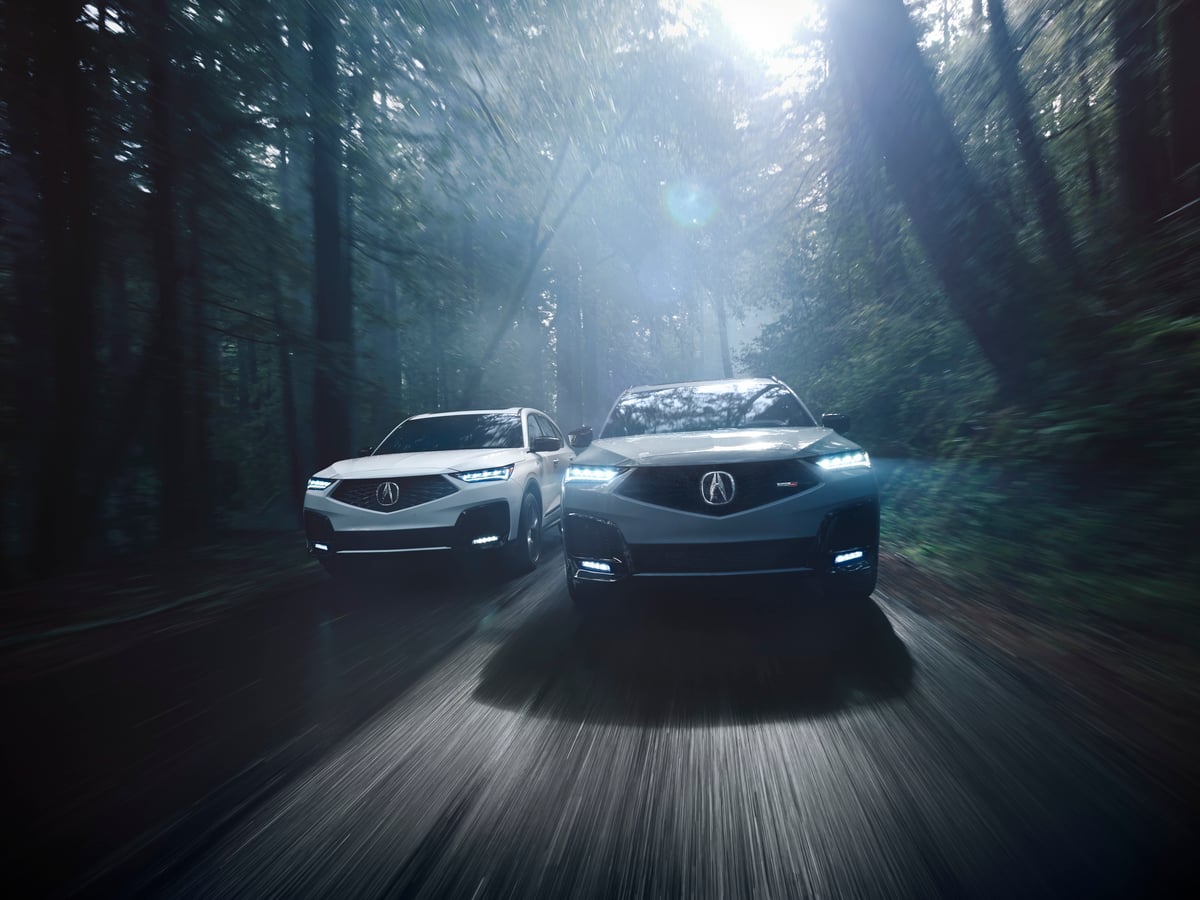 Acura MDX Review image of two 2026 Acura MDX SUVs driving on a forest road