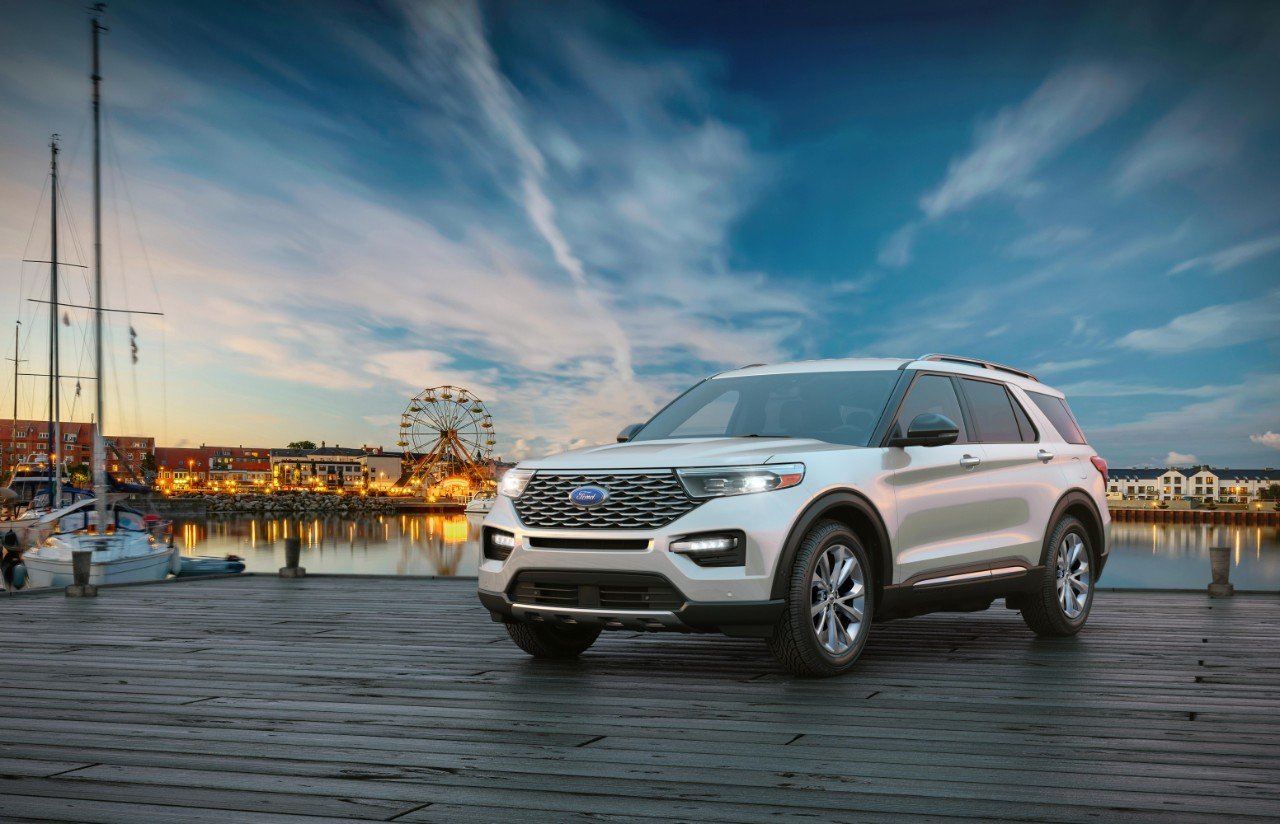 White Ford Explorer parked on a waterfront boardwalk at dusk, featured in our Ford Explorer Review.