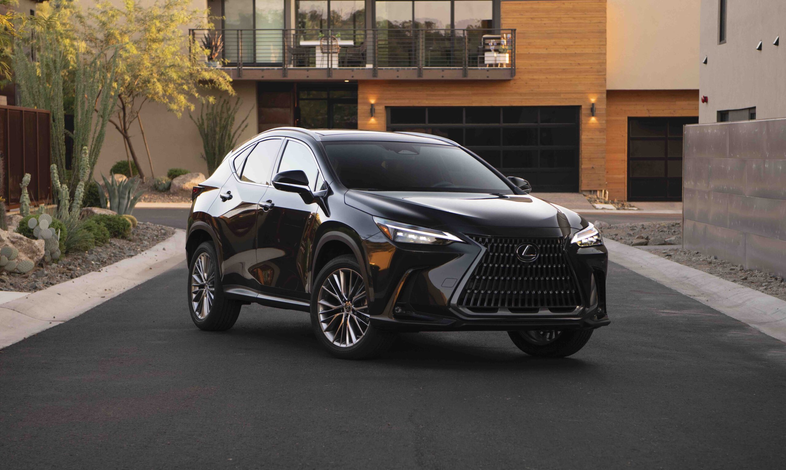 Black Lexus NX luxury SUV parked on a residential street in front of a modern home for a Lexus NX Review.