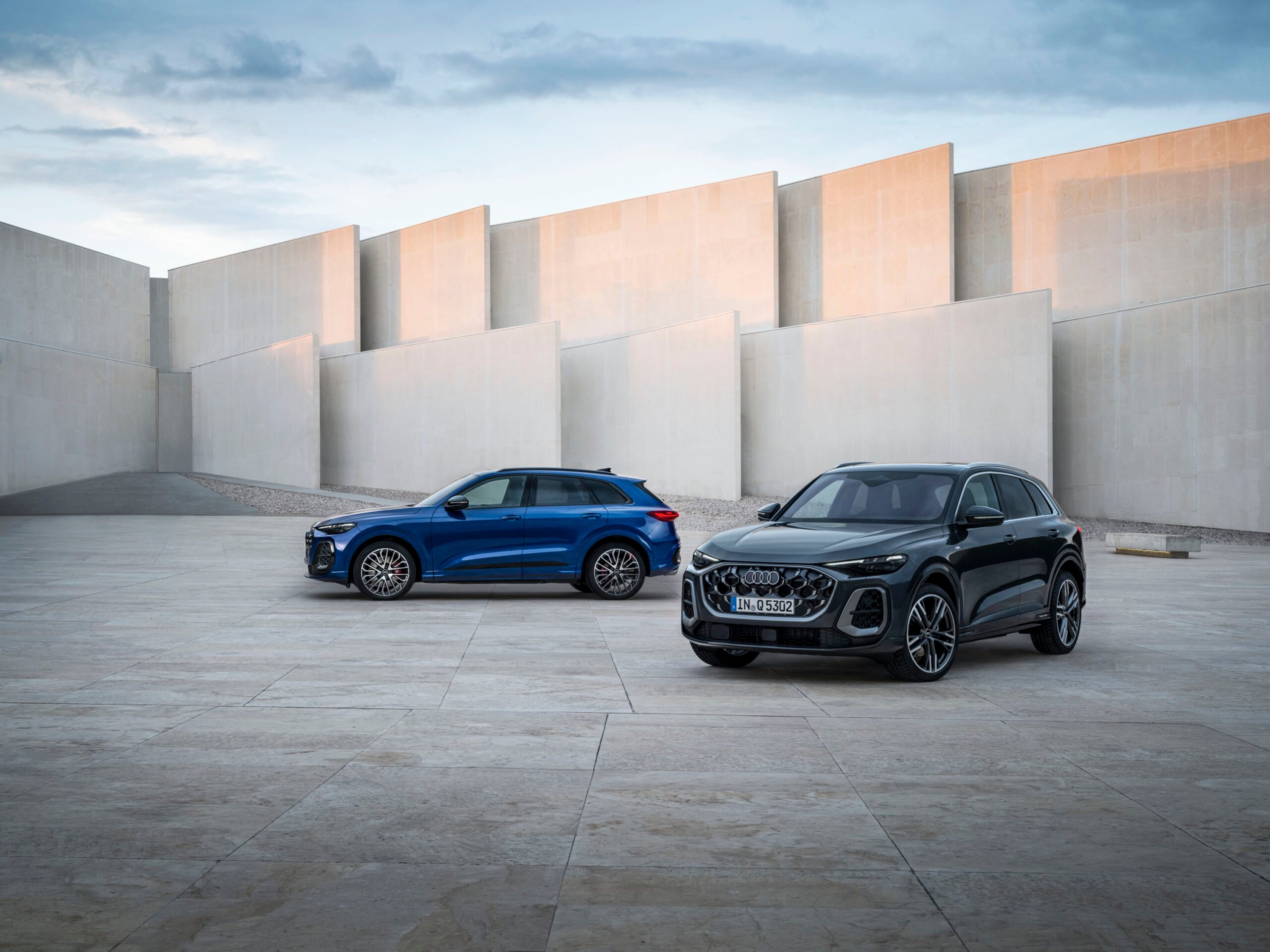 Two 2026 Audi Q5 SUVs parked in a modern concrete courtyard for an Audi Q5 Review.