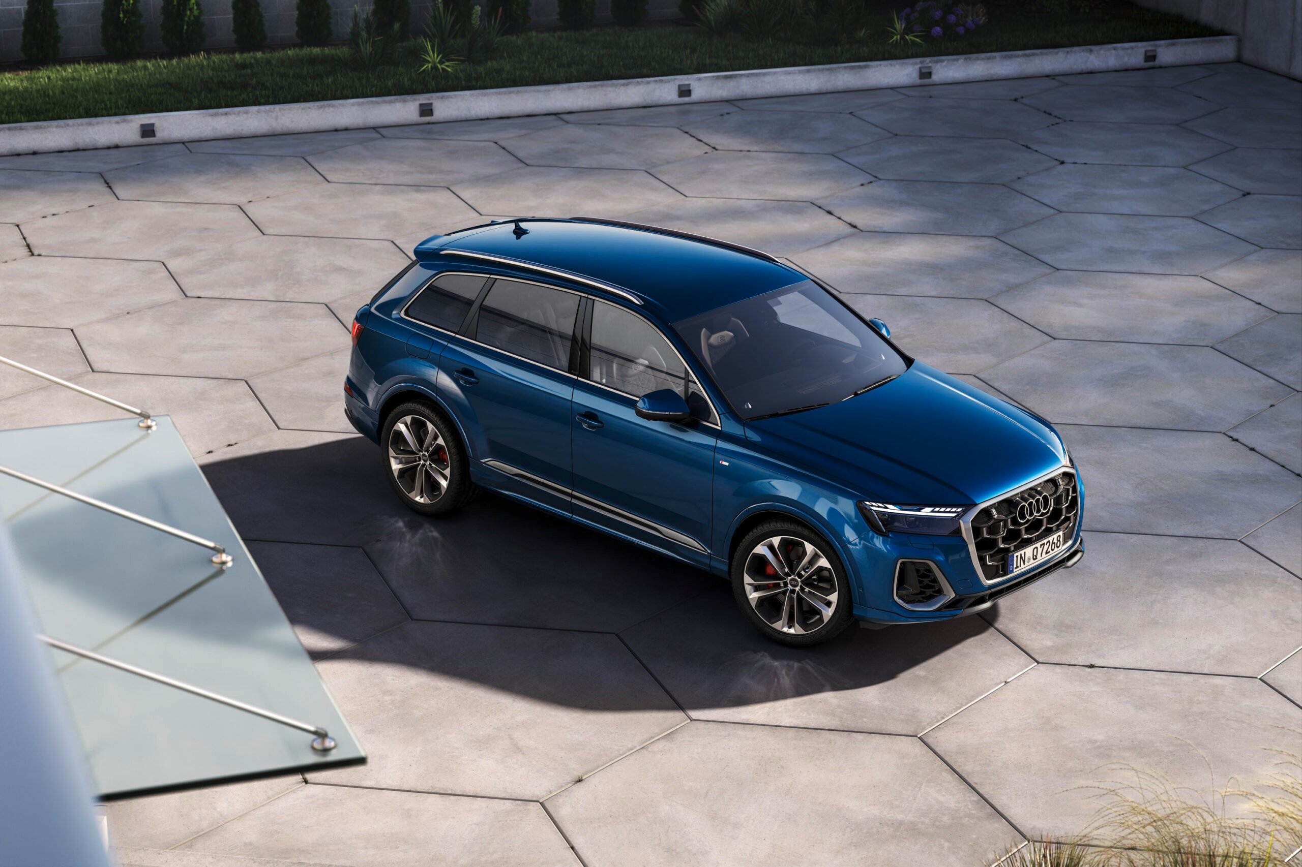 Blue Audi Q7 luxury SUV shown from an elevated angle in a modern courtyard for an Audi Q7 Review.