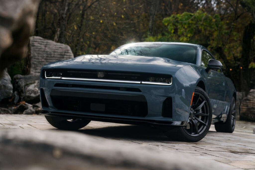 Gray Dodge Charger shown from a low front three-quarter angle on a stone driveway for a Dodge Charger Review.
