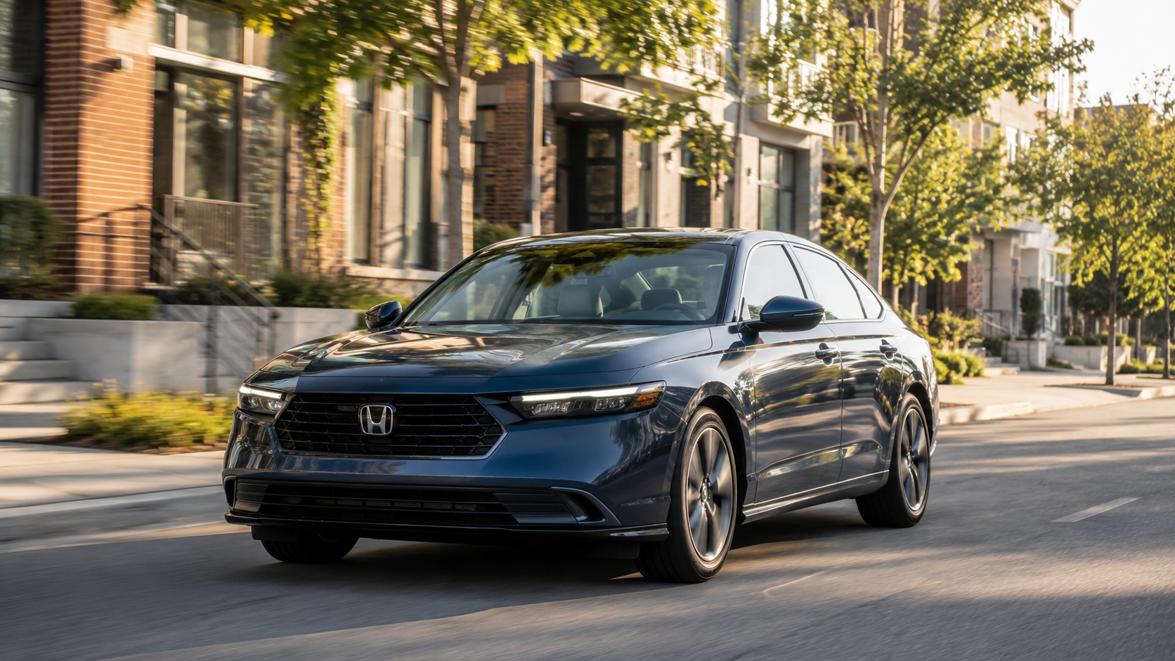Blue Honda sedan driving down a tree-lined urban street, front-left view
