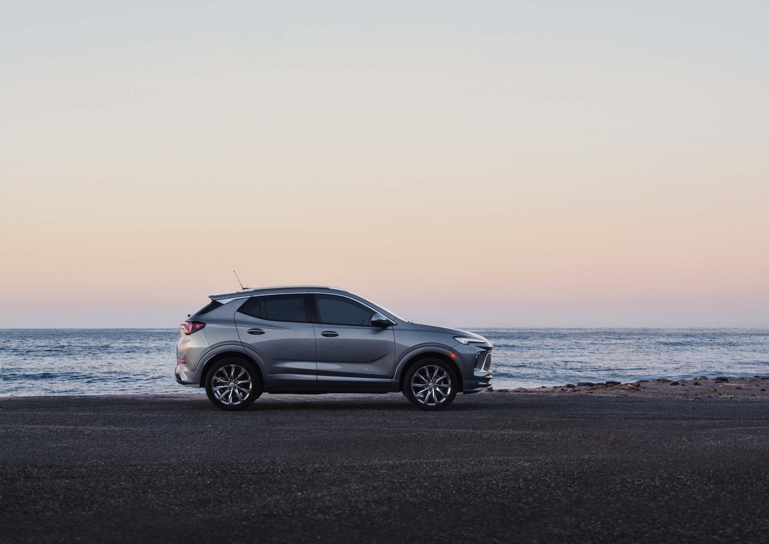 2026 Buick Encore GX in silver parked on a clean suburban street showcasing its sleek subcompact crossover profile