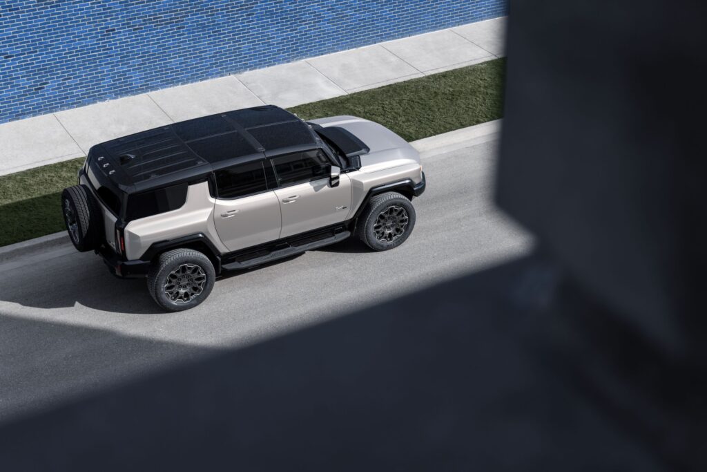 2026 GMC HUMMER EV SUV in dark finish parked on rugged terrain showcasing its bold stance and off-road presence