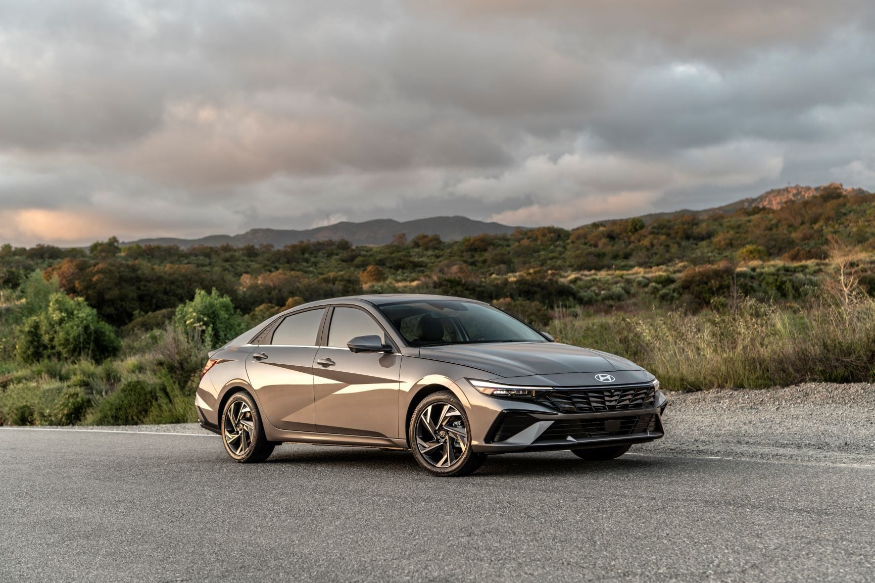 2026 Hyundai Elantra in Cyber Gray Metallic parked on a clean urban street, front three-quarter view showing the sharp angular grille and LED headlights