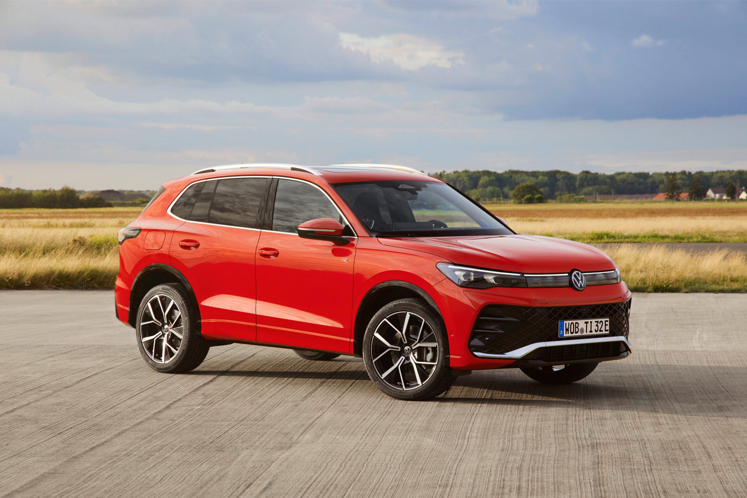 Red 2026 Volkswagen Tiguan SEL R-Line Turbo compact SUV shown from the front three-quarter angle on an open road.