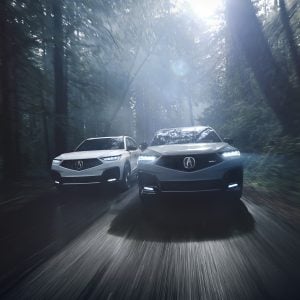 Acura MDX Review image of two 2026 Acura MDX SUVs driving on a forest road