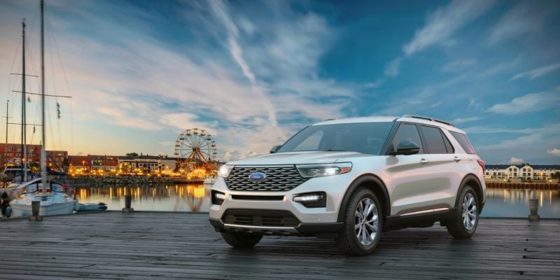 White Ford Explorer parked on a waterfront boardwalk at dusk, featured in our Ford Explorer Review.