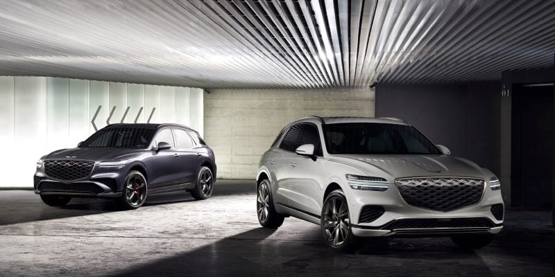 Two Genesis GV70 luxury SUVs shown in a modern indoor garage setting for a Genesis GV70 Review.