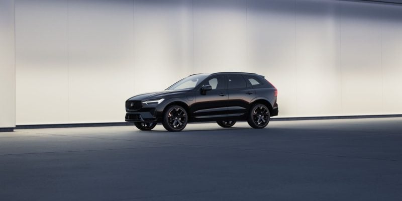 Black Volvo XC60 luxury SUV shown in side profile against a clean modern wall for a Volvo XC60 Review.