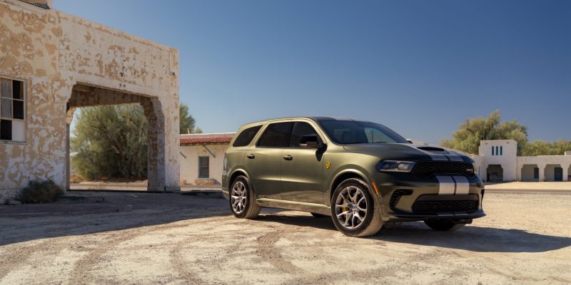Green Dodge Durango parked in a desert-style setting near a stucco building, featured in our Dodge Durango Review.