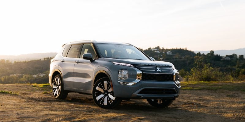 Silver Mitsubishi Outlander SUV parked on a dirt overlook at sunset for a Mitsubishi Outlander Review.