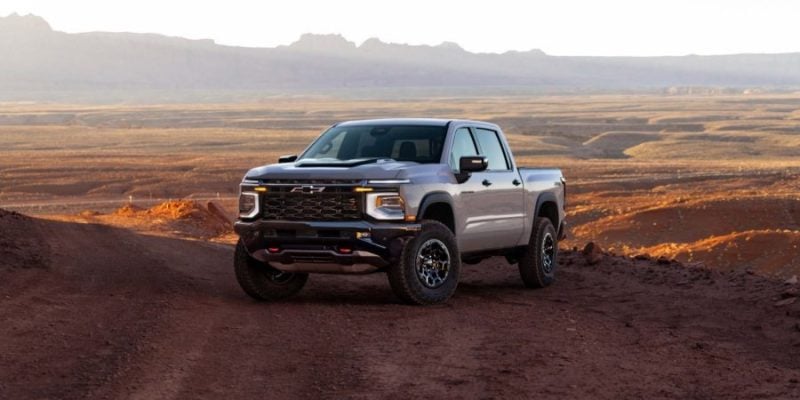 2027 Chevrolet Silverado 1500 off-road truck parked on a desert trail with mountains in the background