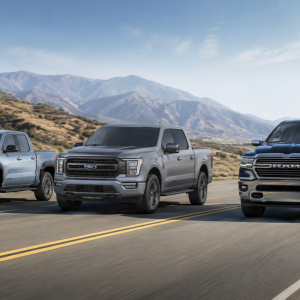 Three modern pickup trucks driving on an open highway for a guide to the best MPG trucks in 2026