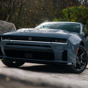 Gray Dodge Charger shown from a low front three-quarter angle on a stone driveway for a Dodge Charger Review.