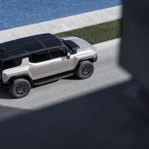 2026 GMC HUMMER EV SUV in dark finish parked on rugged terrain showcasing its bold stance and off-road presence