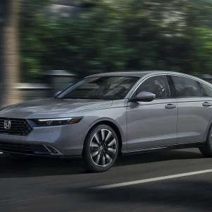 Honda Accord Touring sedan driving on the road, front three-quarter view.