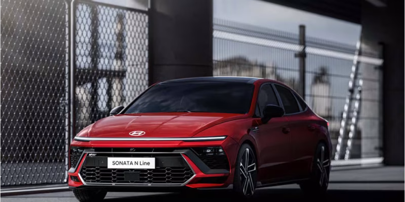 2026 Hyundai Sonata N Line in Abyss Black Pearl on a winding road, showcasing the sedan's aggressive front fascia and 19-inch alloy wheels
