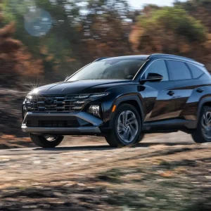 2026 Hyundai Tucson driving on a dirt road, showcasing its bold design and compact SUV stance.