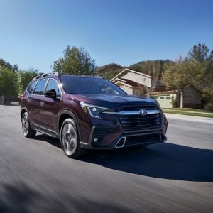 2026 Subaru Ascent Touring in Sapphire Blue Pearl parked on a mountain overlook with a forested valley in the background